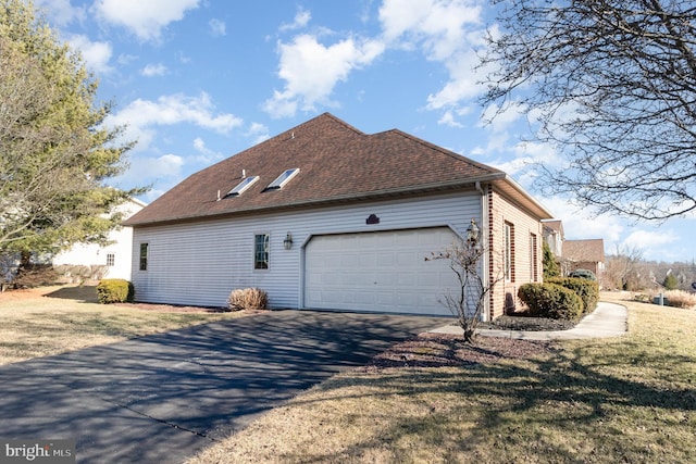 view of side of property featuring aphalt driveway, a yard, a shingled roof, and a garage