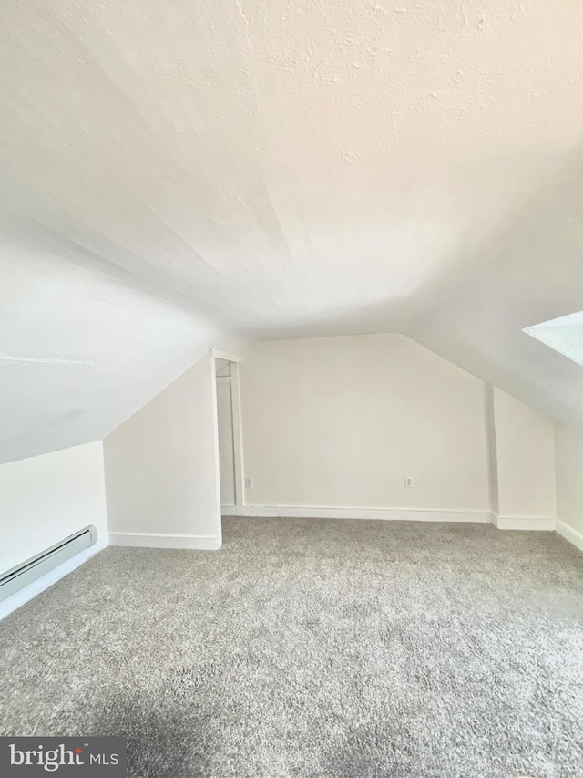 bonus room featuring carpet, a textured ceiling, vaulted ceiling, and baseboard heating