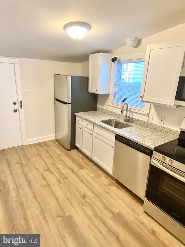 kitchen featuring white cabinetry, sink, stainless steel appliances, and light hardwood / wood-style flooring