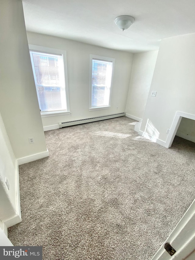 carpeted spare room featuring baseboard heating