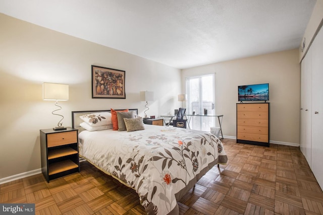 bedroom featuring a closet and parquet floors