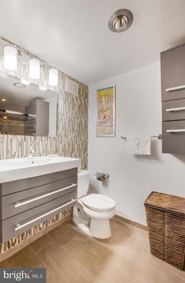 bathroom featuring toilet, a shower, tile patterned floors, and vanity