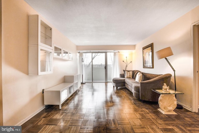 living room featuring dark parquet flooring and a textured ceiling