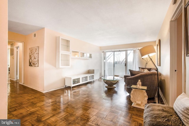 living room with a textured ceiling and dark parquet floors