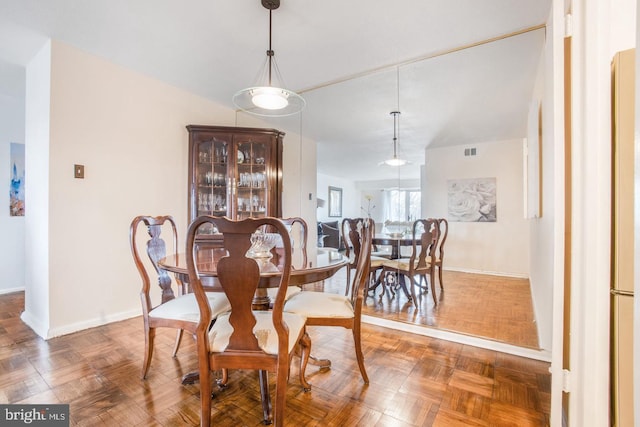 dining area featuring dark parquet flooring