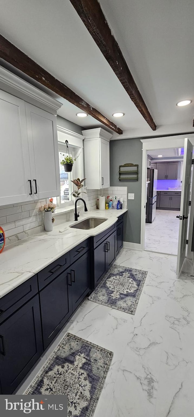 bathroom featuring vanity, tasteful backsplash, and beam ceiling