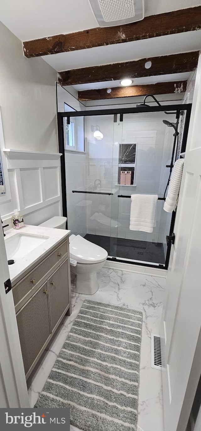 bathroom with toilet, beamed ceiling, vanity, and a shower with door