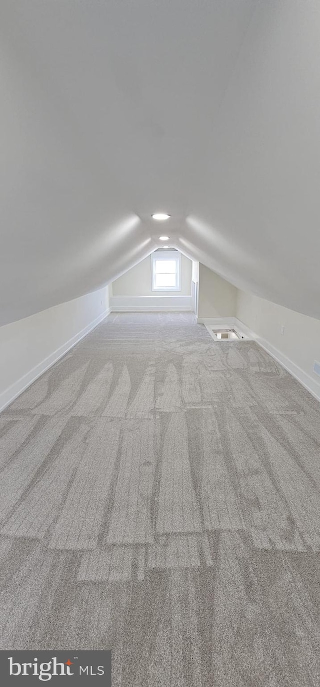 bonus room with lofted ceiling and carpet flooring