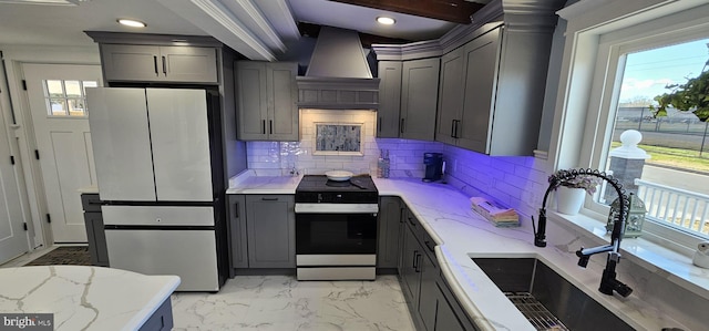 kitchen with gray cabinets, stainless steel appliances, custom exhaust hood, and sink