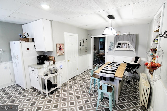 kitchen featuring white cabinets, a paneled ceiling, and white refrigerator