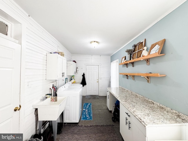 clothes washing area featuring cabinets, washer and dryer, crown molding, and wood walls