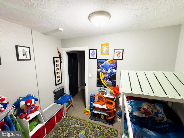 game room with a textured ceiling and carpet floors