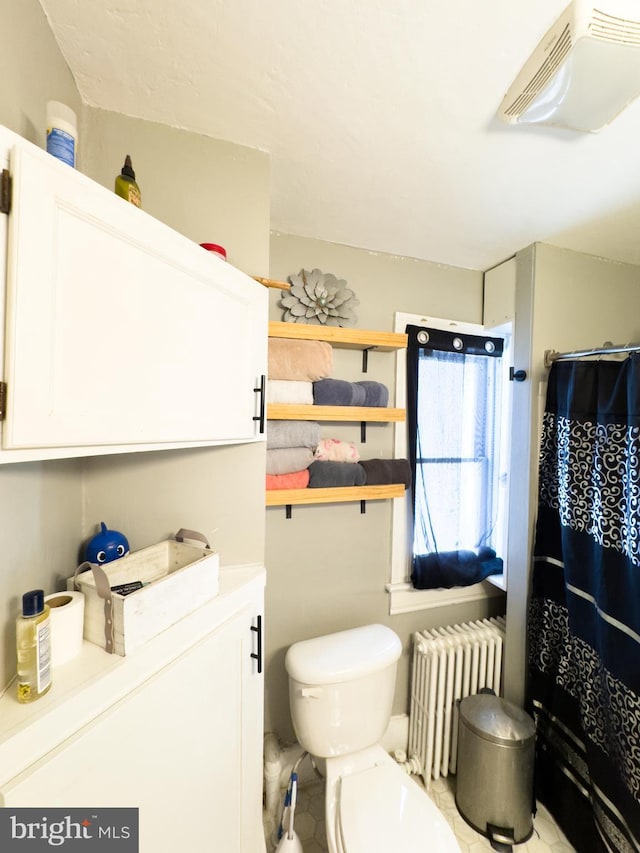 bathroom featuring radiator and toilet