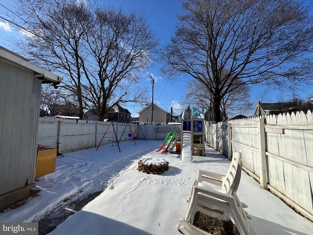 yard layered in snow with a playground