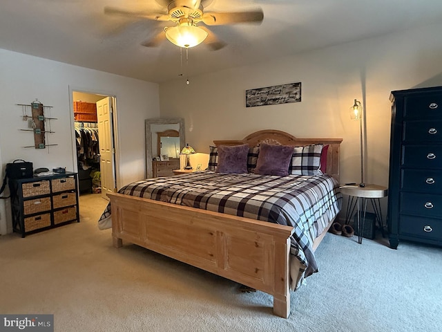 carpeted bedroom featuring ceiling fan, a closet, and a spacious closet