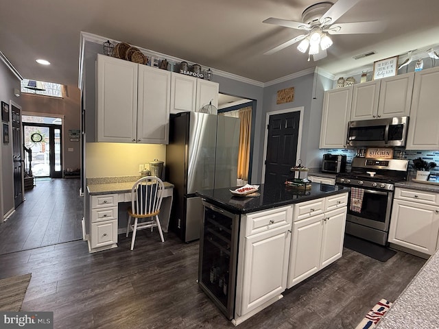 kitchen with white cabinets, beverage cooler, dark hardwood / wood-style flooring, stainless steel appliances, and ornamental molding