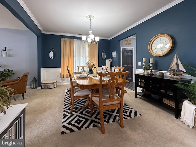 dining space featuring a chandelier, crown molding, and light colored carpet