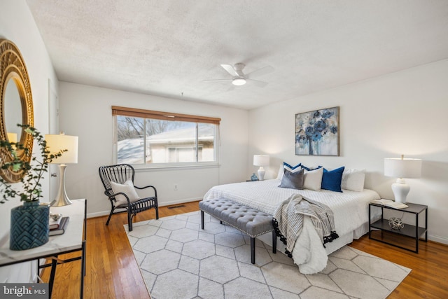 bedroom featuring ceiling fan, a textured ceiling, and wood-type flooring