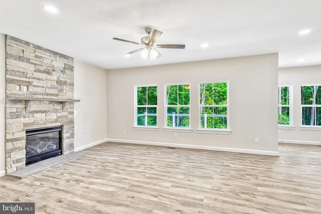 unfurnished living room featuring ceiling fan, a fireplace, and light hardwood / wood-style floors