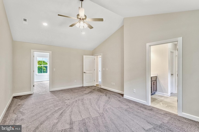 carpeted spare room featuring ceiling fan and vaulted ceiling