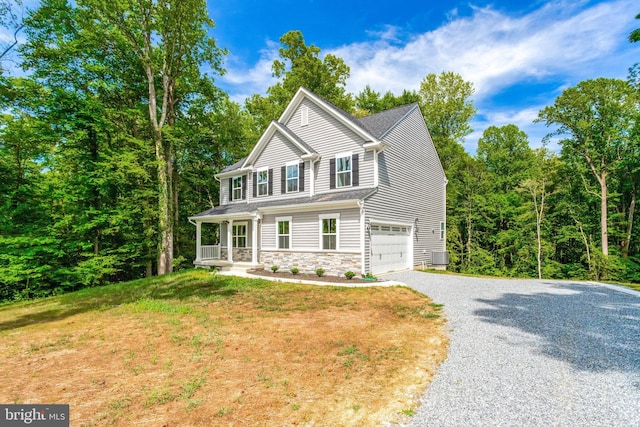 view of front of home with a front lawn, a porch, and a garage