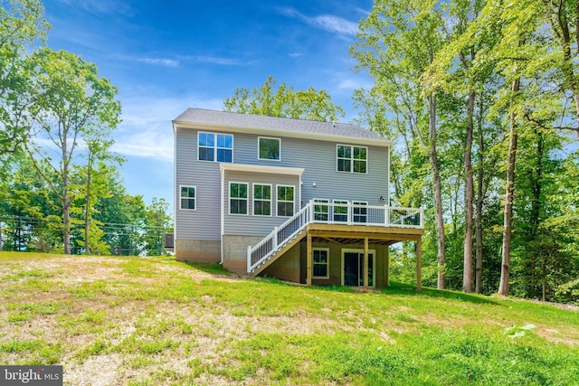 rear view of property with a deck and a yard