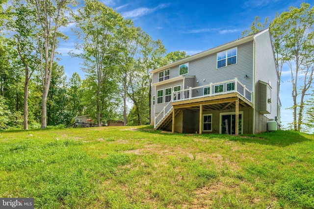 rear view of property with a wooden deck and a yard