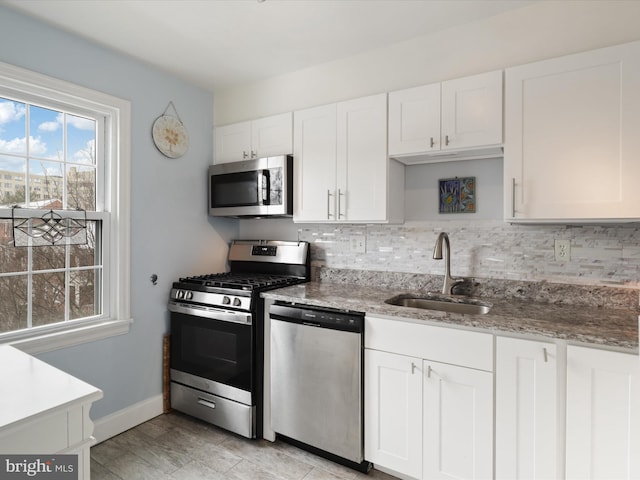 kitchen with white cabinets, appliances with stainless steel finishes, and sink