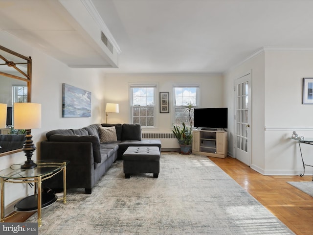 living room with radiator, crown molding, and parquet flooring