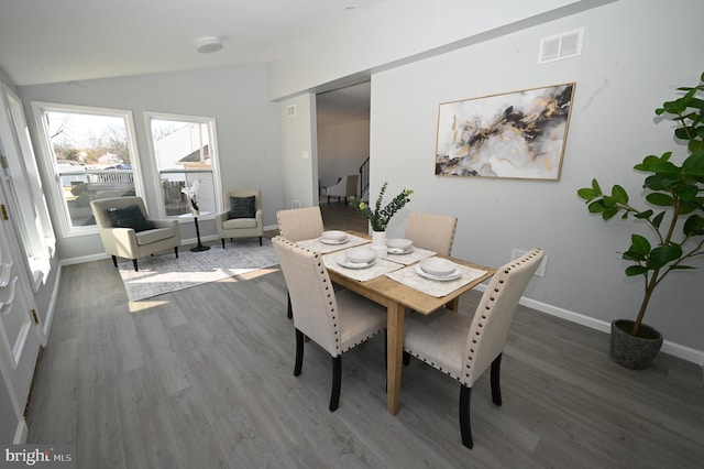 dining area featuring dark hardwood / wood-style flooring and lofted ceiling