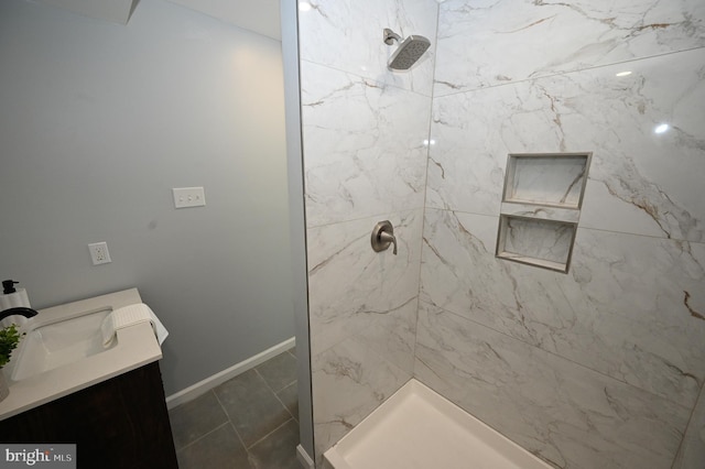 bathroom featuring a tile shower, vanity, and tile patterned floors