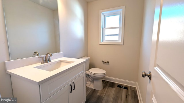 bathroom featuring vanity, hardwood / wood-style flooring, and toilet