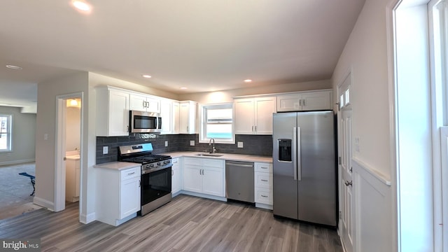 kitchen with appliances with stainless steel finishes, white cabinetry, plenty of natural light, and sink