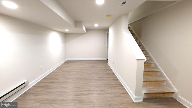 basement with a baseboard radiator and light wood-type flooring