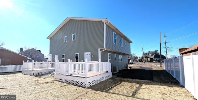 back of house with a deck and central AC unit