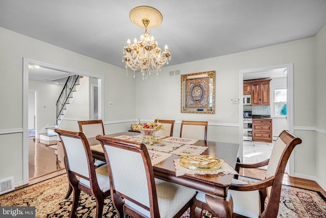 dining room featuring light hardwood / wood-style flooring and an inviting chandelier