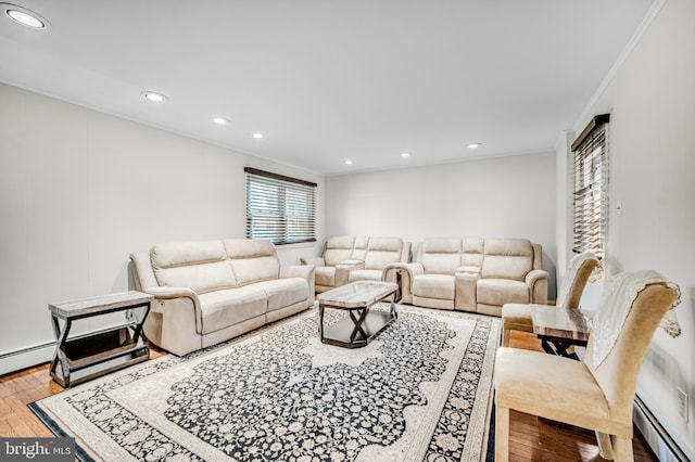 living room with light wood-type flooring, a baseboard radiator, and crown molding