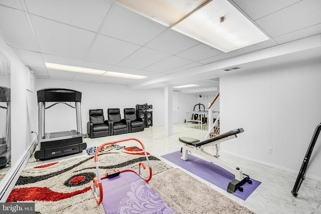 workout area with a paneled ceiling and baseboard heating