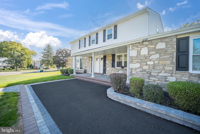 view of front of house with covered porch and a front lawn