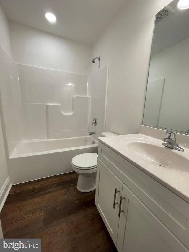 full bath featuring toilet, recessed lighting, wood finished floors, vanity, and bathing tub / shower combination