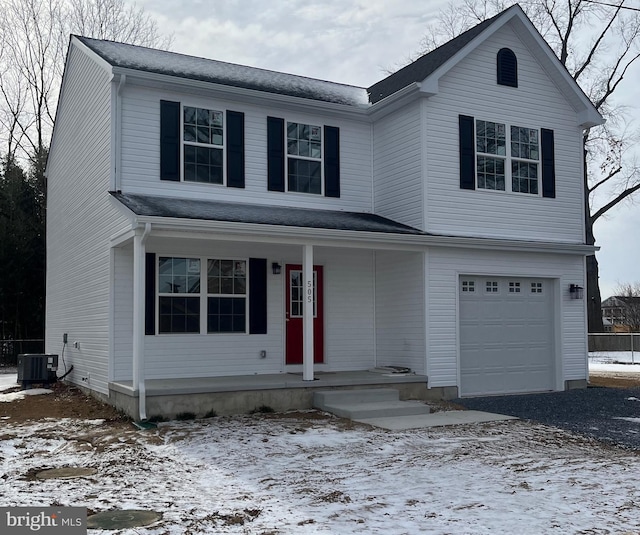 traditional-style home with covered porch, central AC, and an attached garage