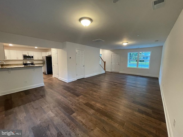 unfurnished living room with dark wood-type flooring