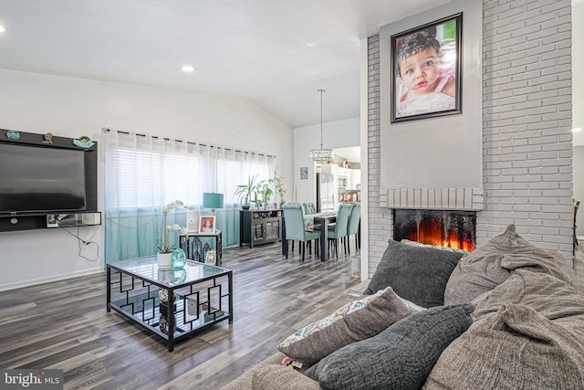 living room featuring a fireplace, hardwood / wood-style flooring, and vaulted ceiling