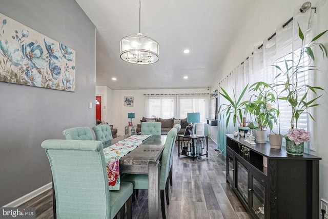 dining area with dark hardwood / wood-style flooring and a notable chandelier