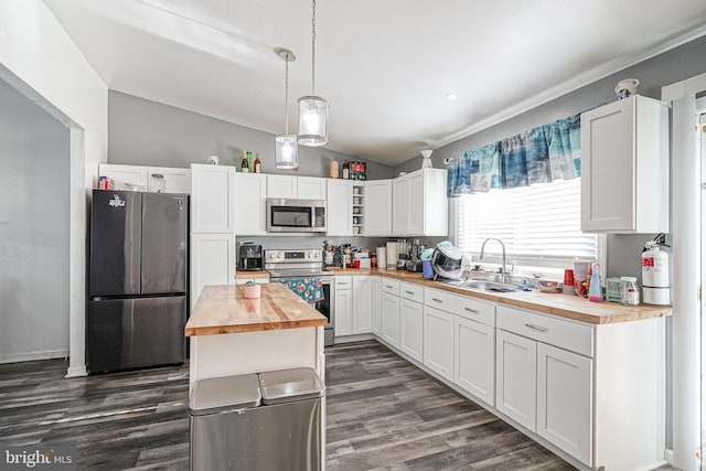 kitchen with butcher block countertops, white cabinetry, sink, and appliances with stainless steel finishes