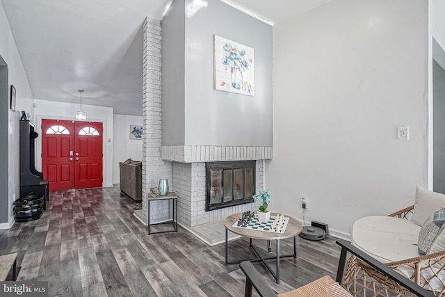 living room with dark wood-type flooring and a brick fireplace