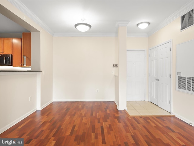 entryway featuring ornate columns, ornamental molding, and hardwood / wood-style floors