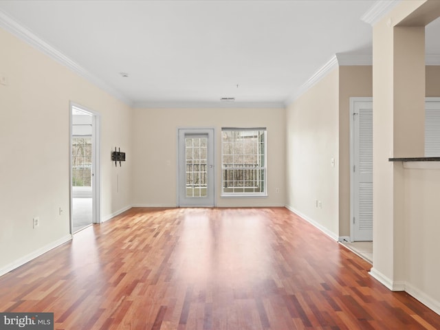 unfurnished living room with hardwood / wood-style floors and ornamental molding