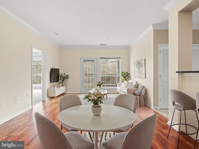 dining space featuring crown molding and hardwood / wood-style flooring