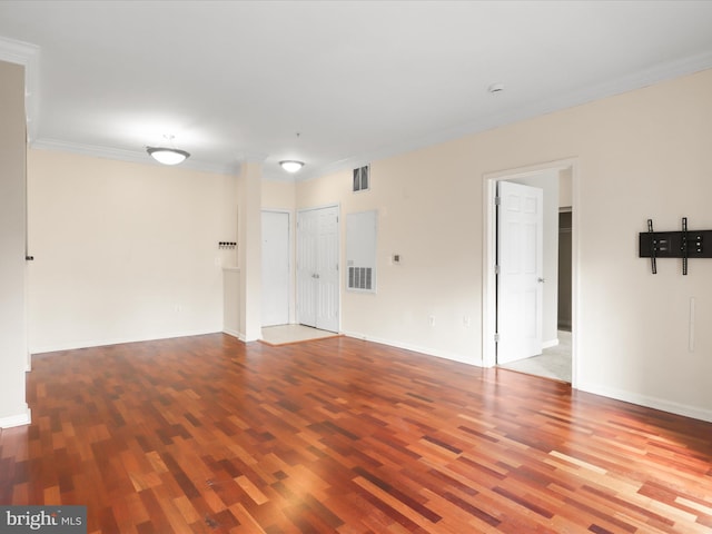 empty room featuring crown molding and hardwood / wood-style floors